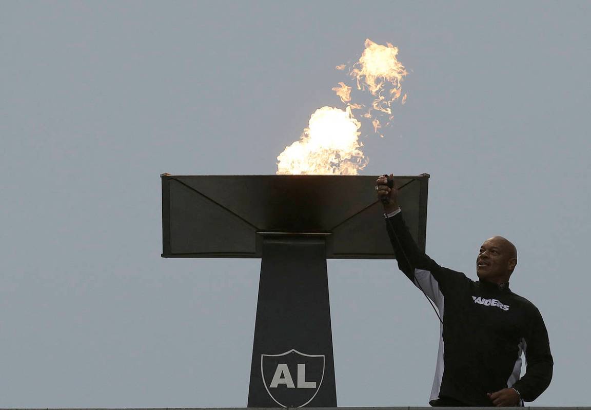 Former NFL football player Greg Townsend lights a ceremonial torch for former Oakland Raiders o ...