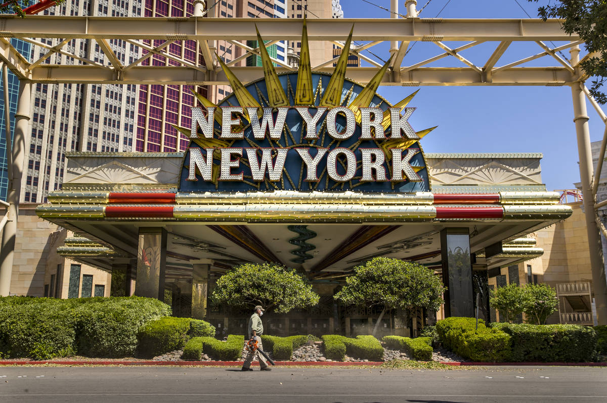 A landscaper blows clippings after trimming the bushes in front of New York-New York about the ...