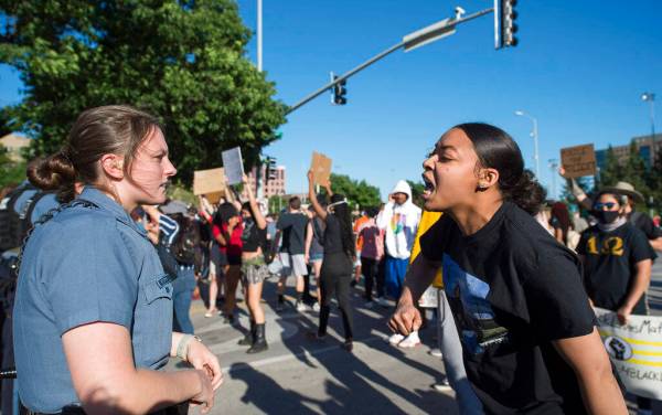 In this May 29, 2020, photo, a police officer stands as a young woman screamed at her during a ...