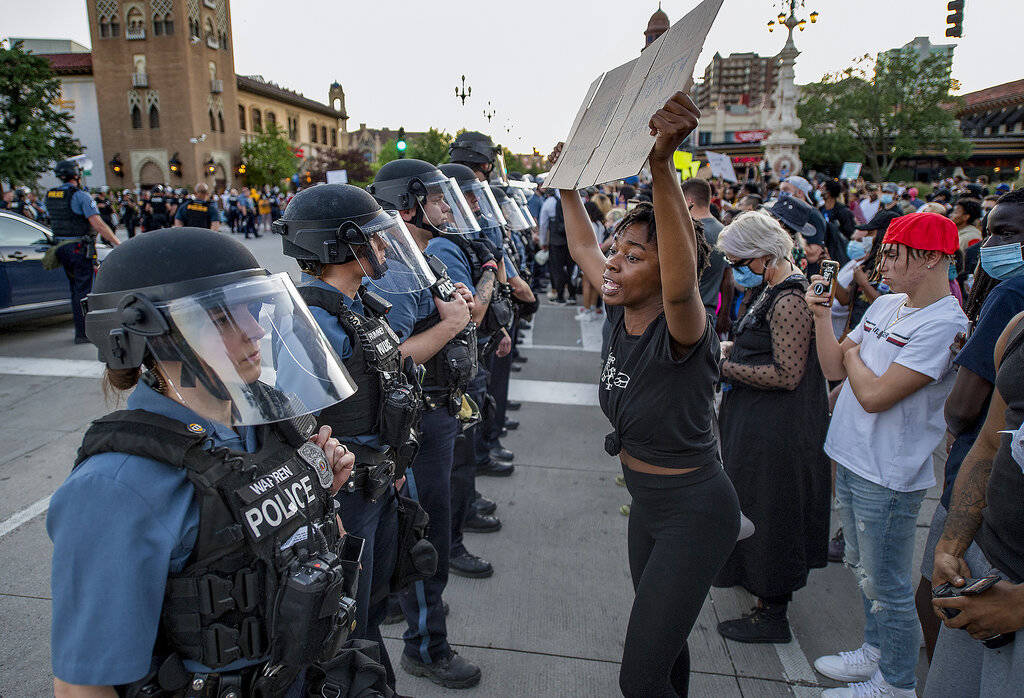 In this May 29, 2020, photo, a woman holds a placard as she screams "You have no authority ...
