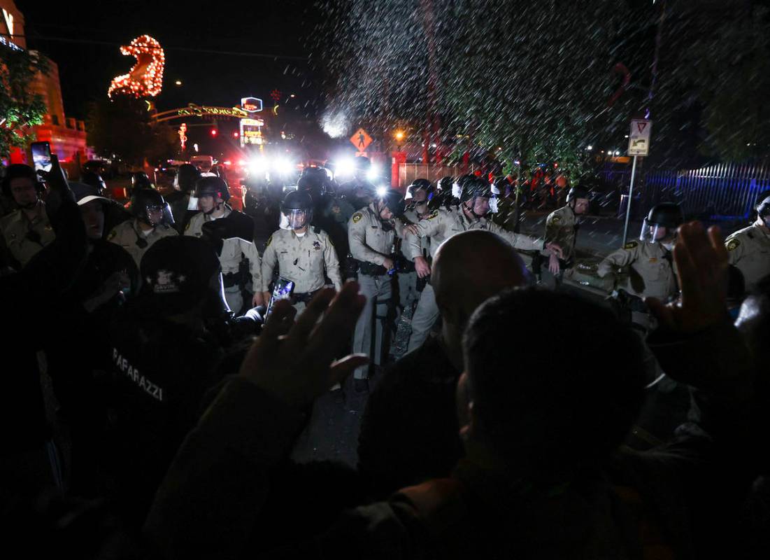 Water bottles are thrown at police officers as people protest the death of George Floyd in down ...