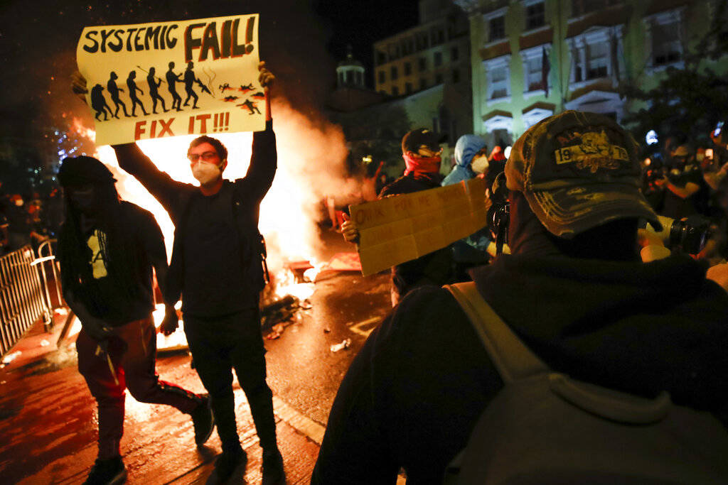 Demonstrators protest the death of George Floyd, Sunday, May 31, 2020, near the White House in ...