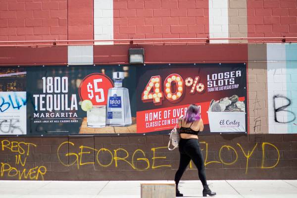 A woman photographs graffiti commemorating George Floyd, who was killed by Minneapolis police, ...
