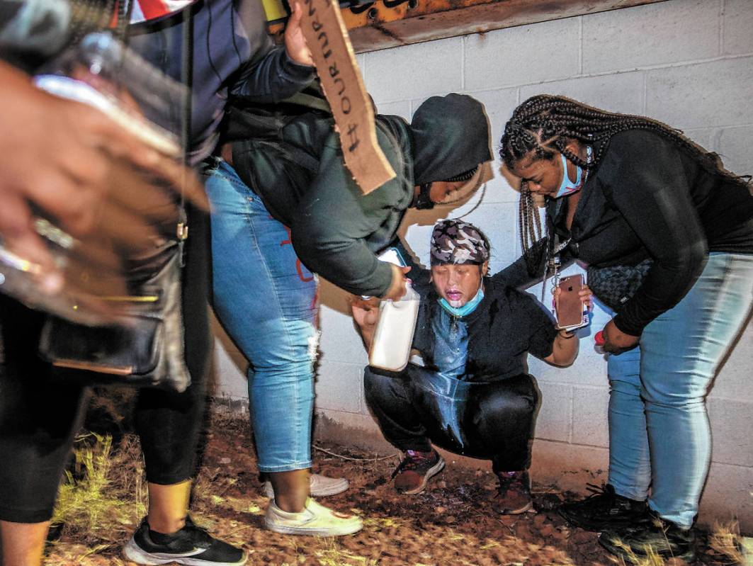 Protesters come to the aid of another who was tear gassed in the eyes by Las Vegas Police fire ...