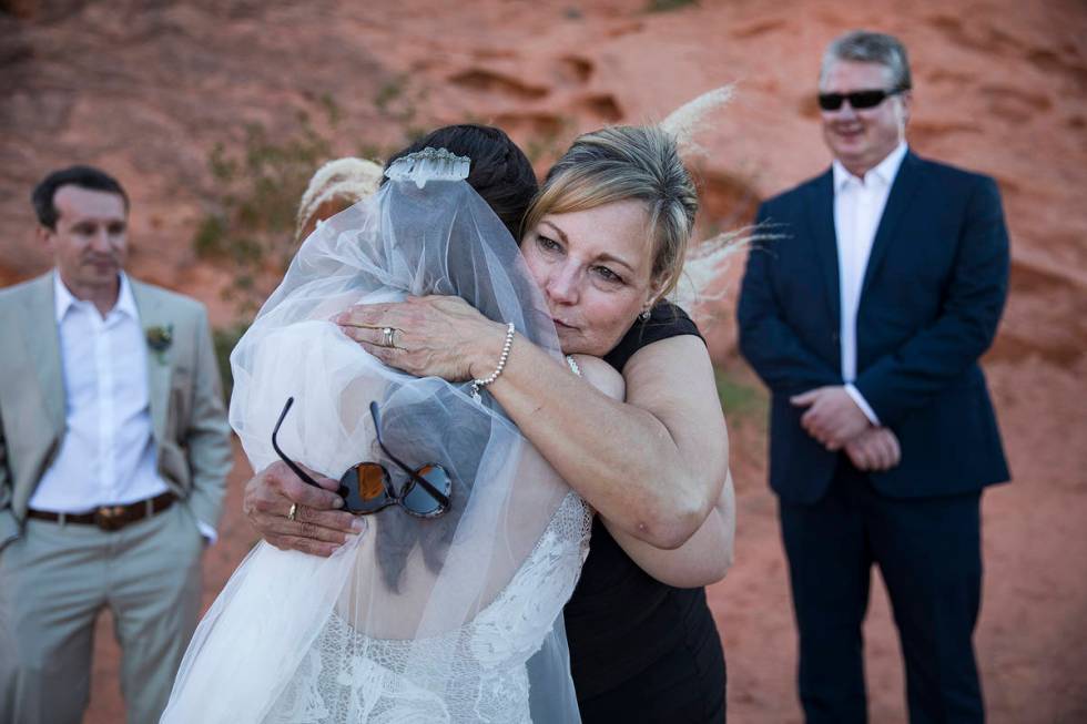 Ellen Owczarek hugs her daughter, Ashley, following her wedding as son-in-law Will Hinder, left ...