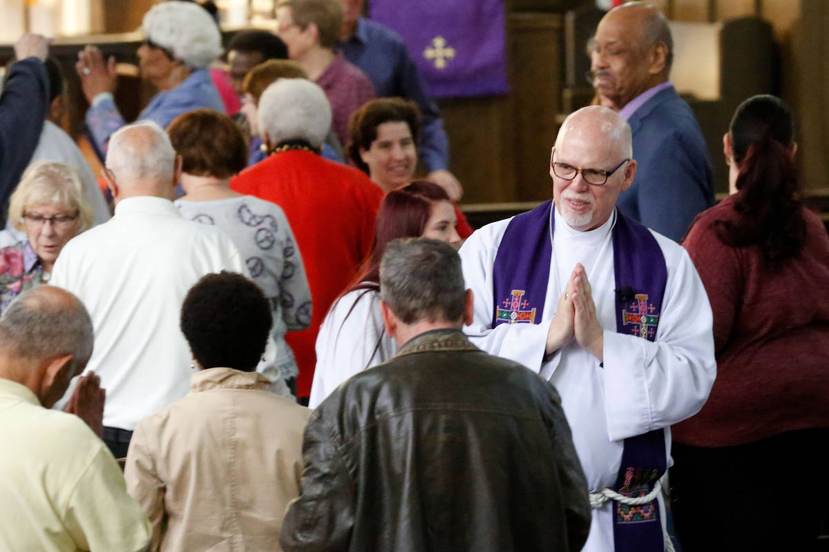 The Rev. J. Barry Vaughn, right, exchanges the sign of peace during a Mass celebrated at Christ ...