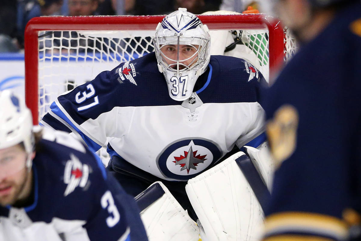 Winnipeg Jets goalie Connor Hellebuyck (37) looks on during the third period of an NHL hockey g ...