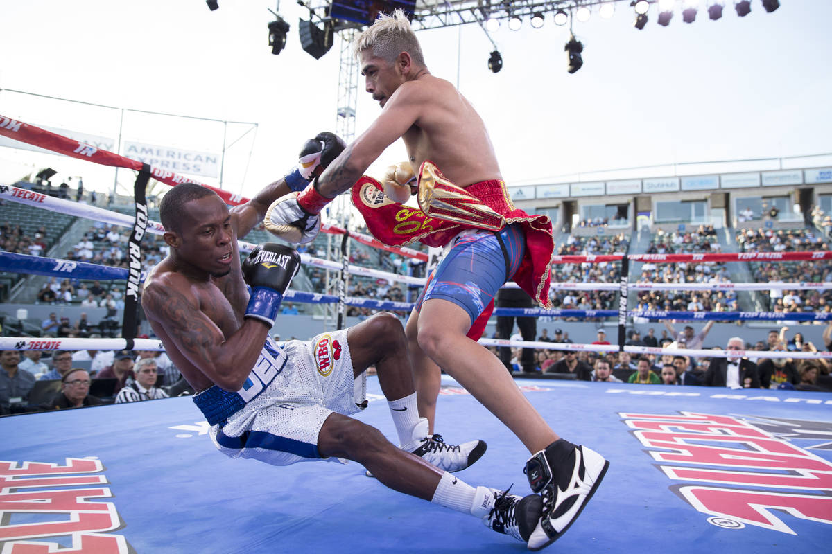 Jessie Magdaleno, right, knocks down Adeilson Dos Santos in their WBO World Championship super ...