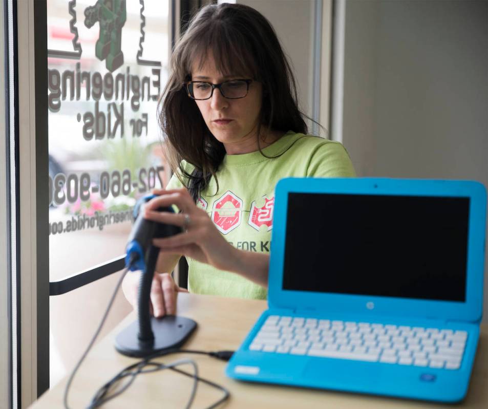 Elise Silva, part owner and teacher at Engineering For Kids, adjusts the new check-in station t ...