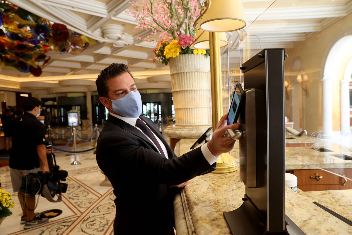 Andy Meese, MGM Resorts vice president of hotel operations, shows how to use a mobile device as ...