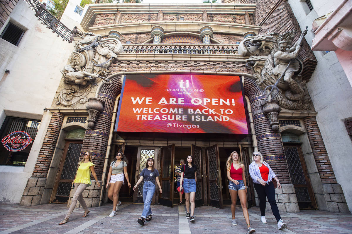 Guests walk under a large sign welcoming tourists back to TI on Thursday, June 4, 2020, in Las ...