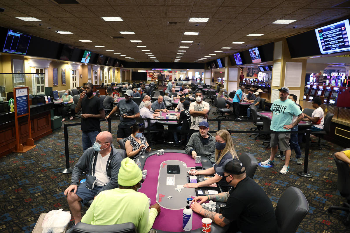 People play poker during the first day of reopening at The Orleans hotel-casino in Las Vegas, T ...