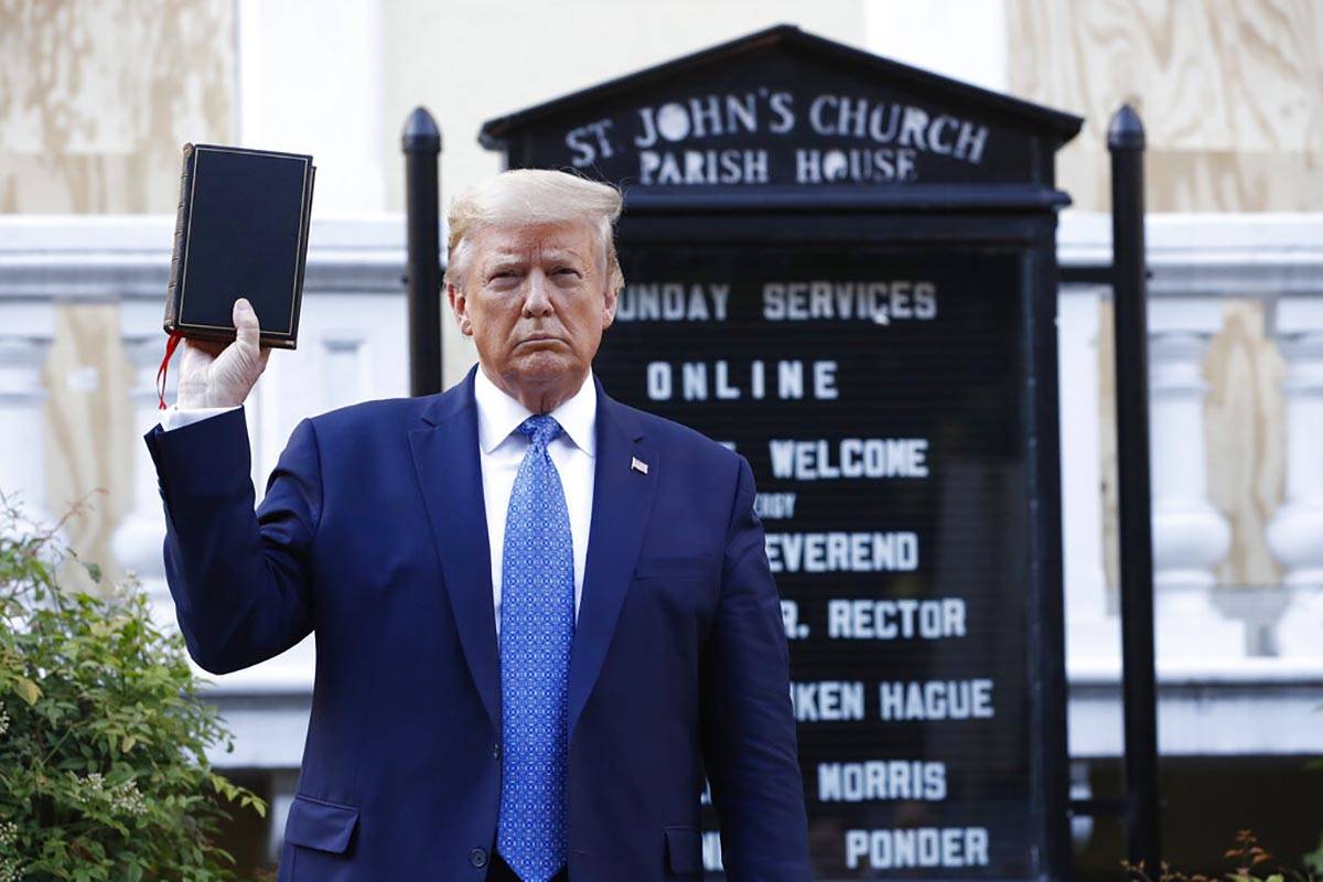 President Donald Trump holds a Bible as he visits outside St. John's Church across Lafayette Pa ...