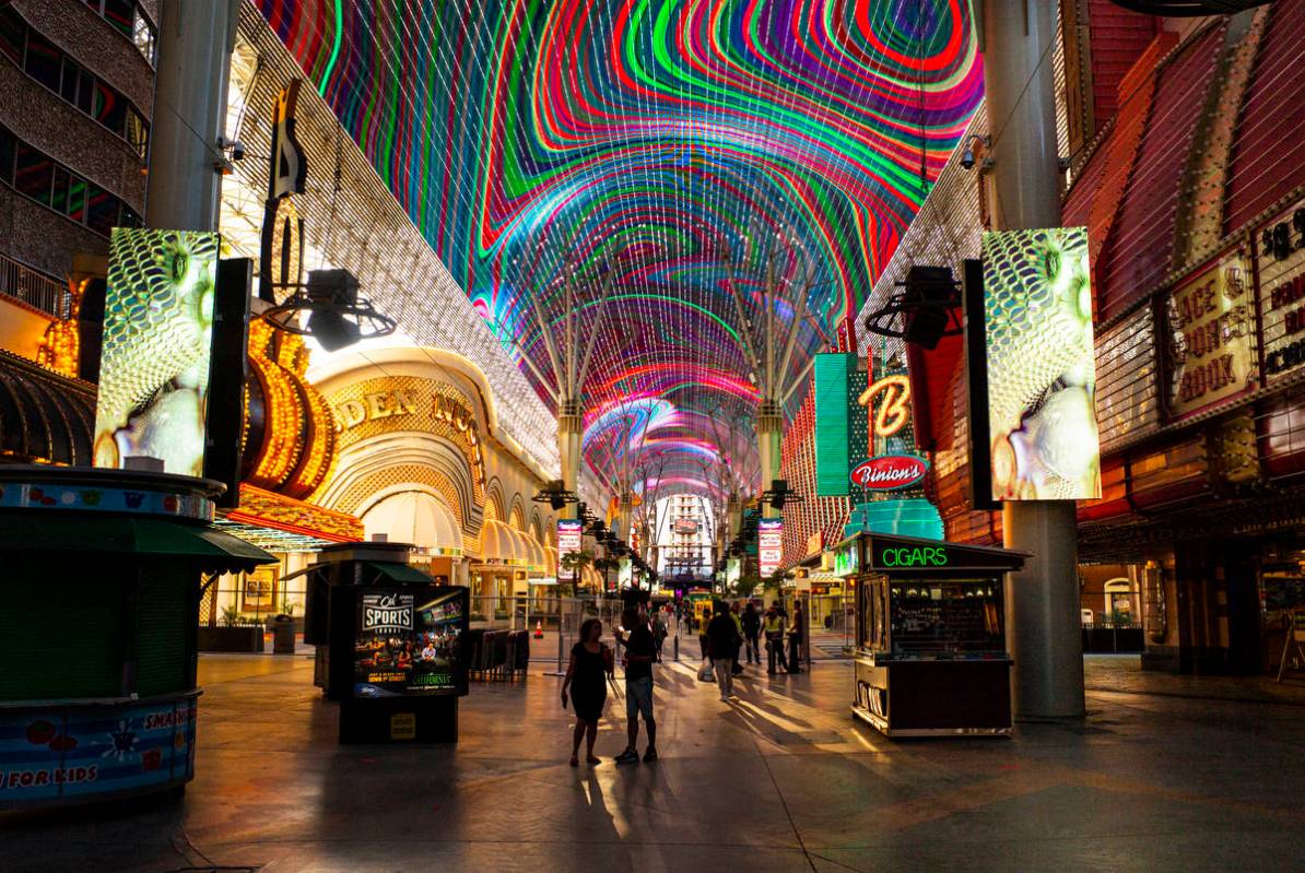 People walk around the Fremont Street Experience as hotel-casinos reopen in downtown Las Vegas ...