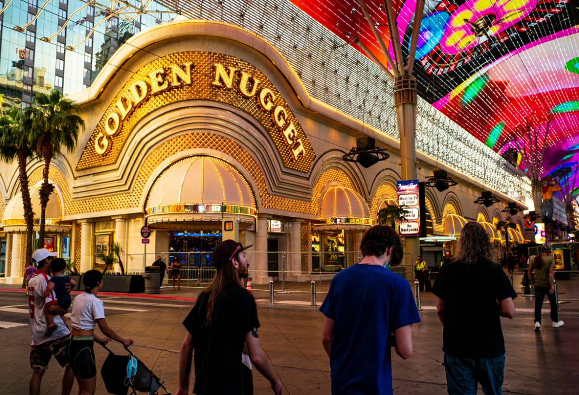 People walk around the Fremont Street Experience as hotel-casinos reopen in downtown Las Vegas ...