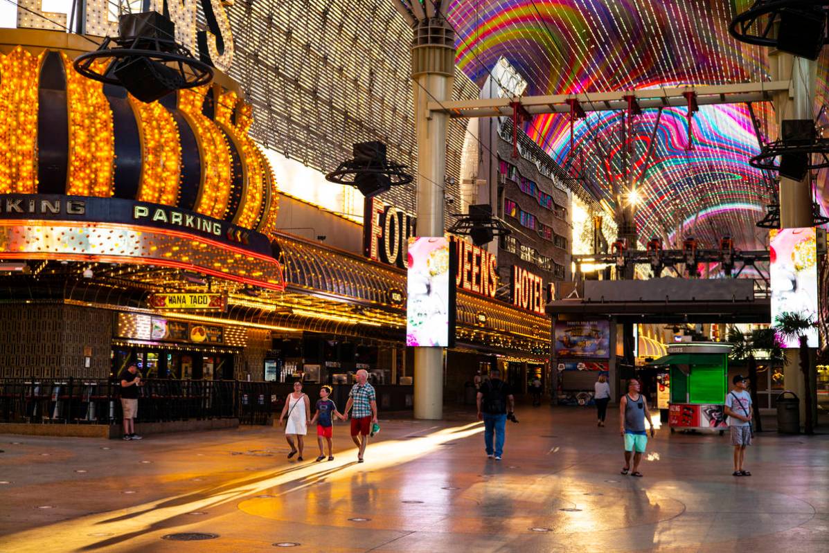 People walk around the Fremont Street Experience as hotel-casinos reopen in downtown Las Vegas ...