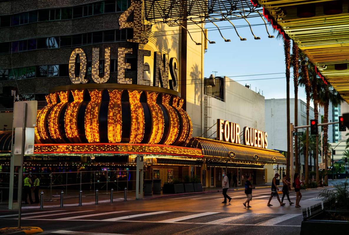 People walk around the Fremont Street Experience as hotel-casinos reopen in downtown Las Vegas ...