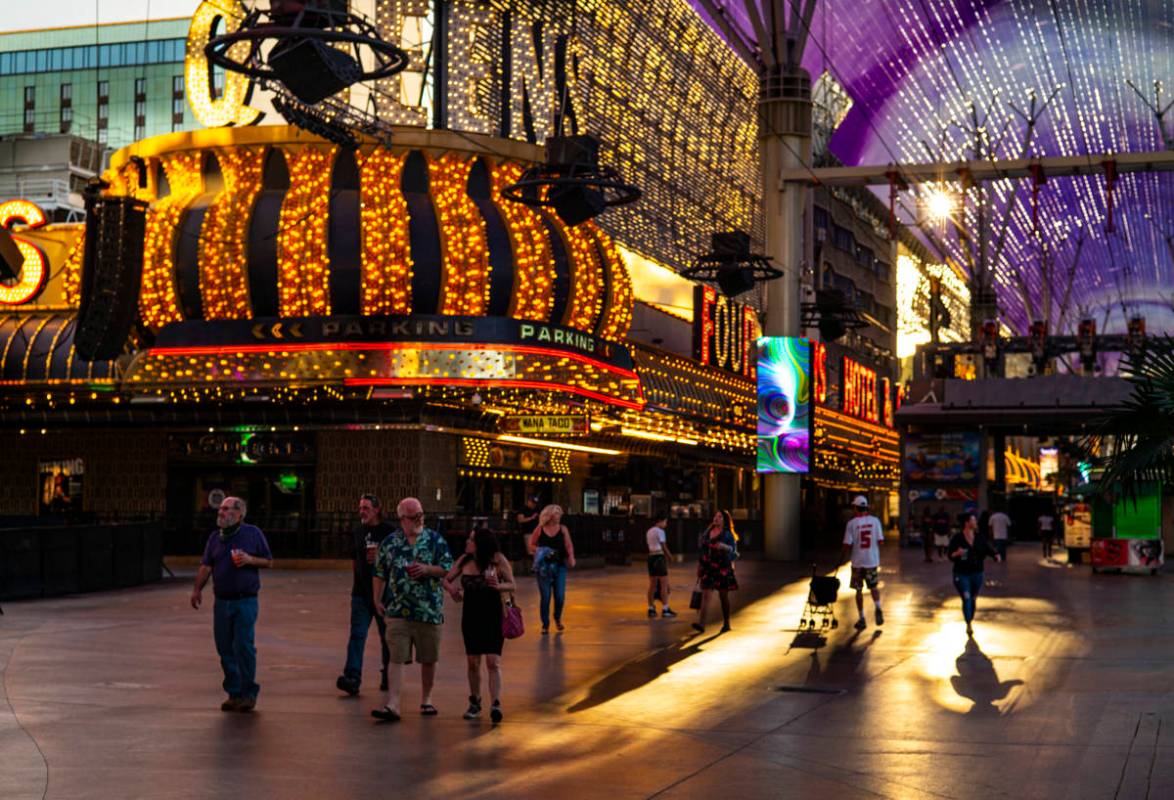 People walk around the Fremont Street Experience as hotel-casinos reopen in downtown Las Vegas ...