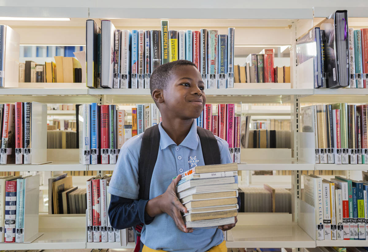 Trey'vion Hilln-Cowans, 9, has his stack of books picked out from the East Las Vegas Library in ...