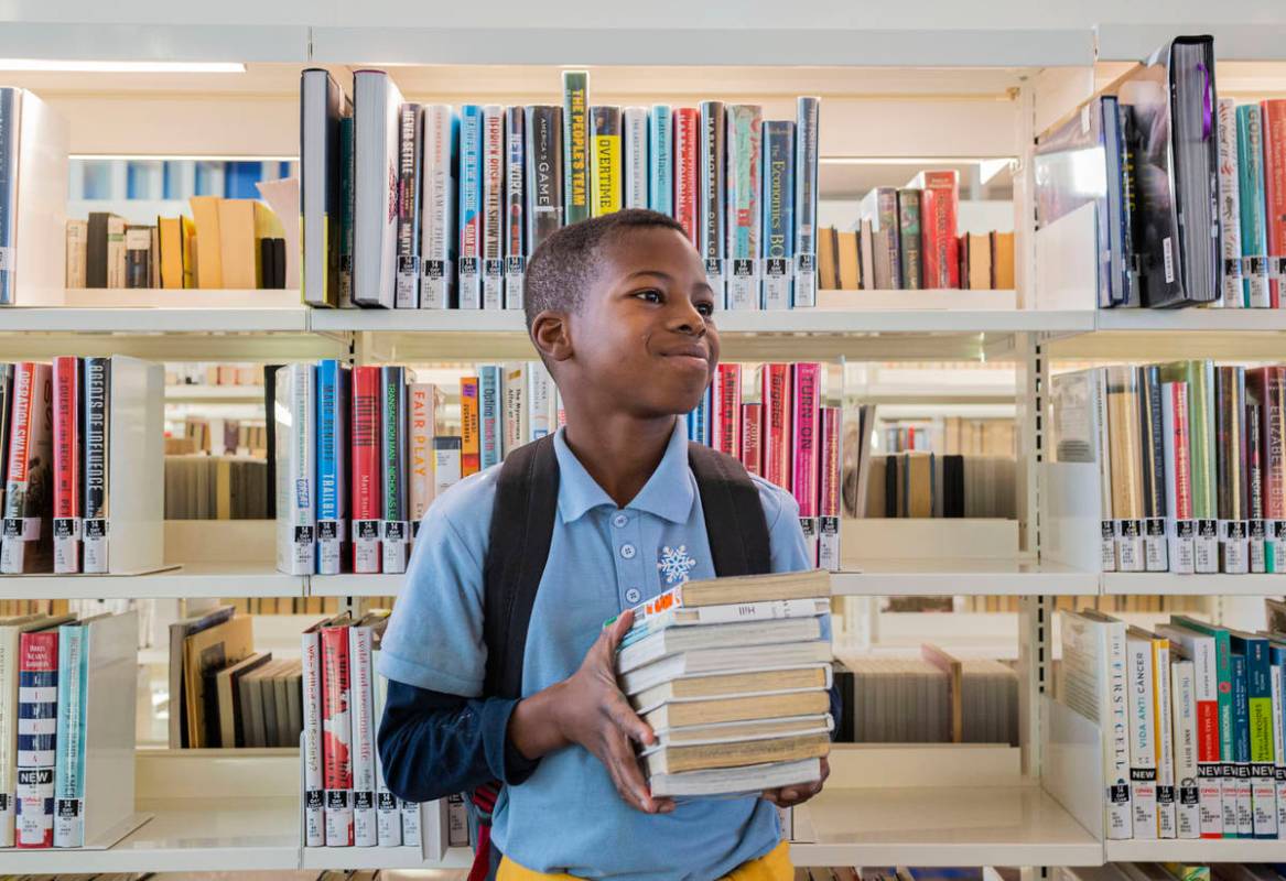 Trey'vion Hilln-Cowans, 9, has his stack of books picked out from the East Las Vegas Library in ...