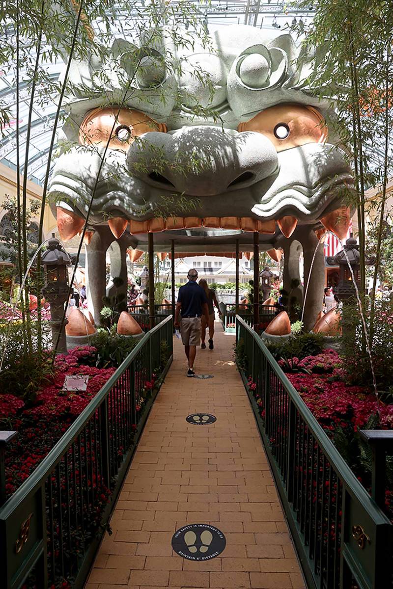 Guests maintain social distance inside the Conservatory at the Bellagio on the Strip in Las Veg ...