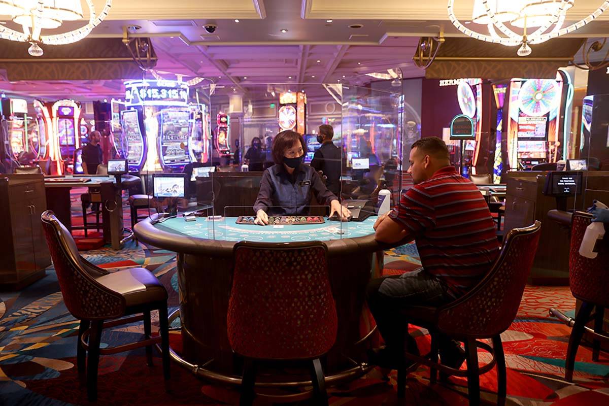 A guests plays blackjack at the Bellagio on the Las Vegas Strip as the resort reopens after 78 ...