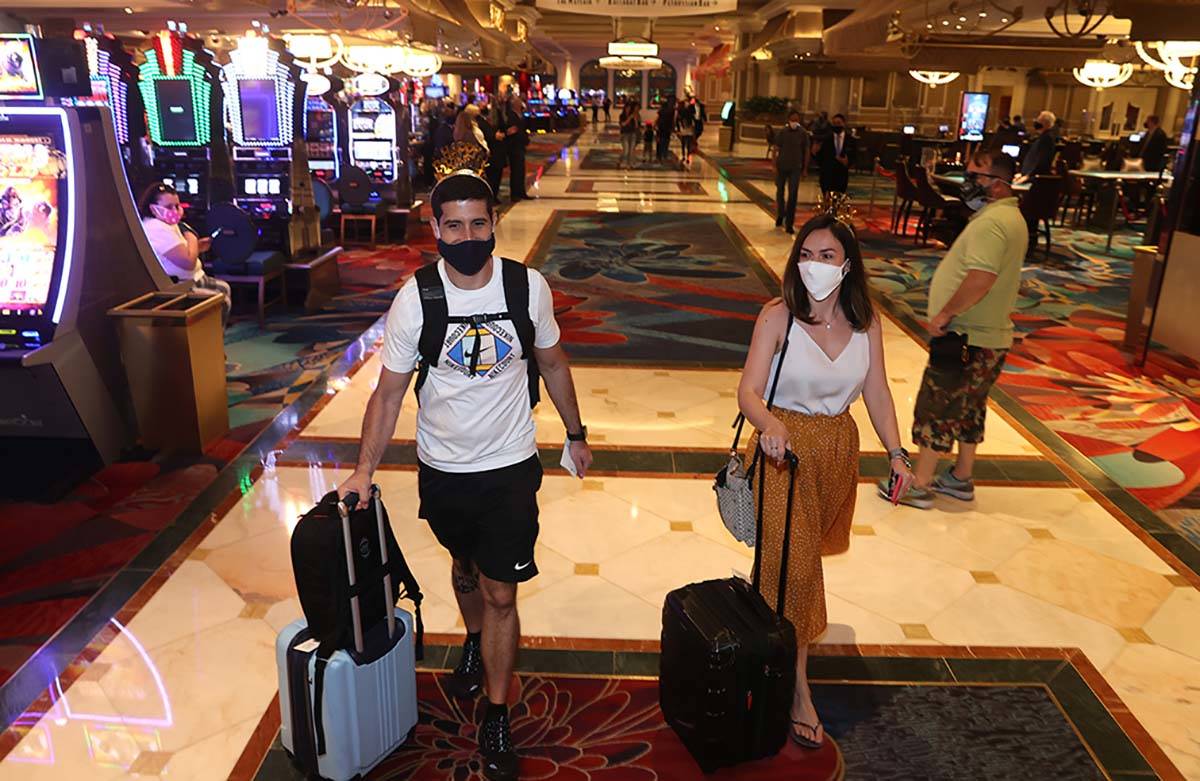 Jorge Aith and his wife, Tassia Reis, from Brazil, head to their room at the Bellagio on the La ...