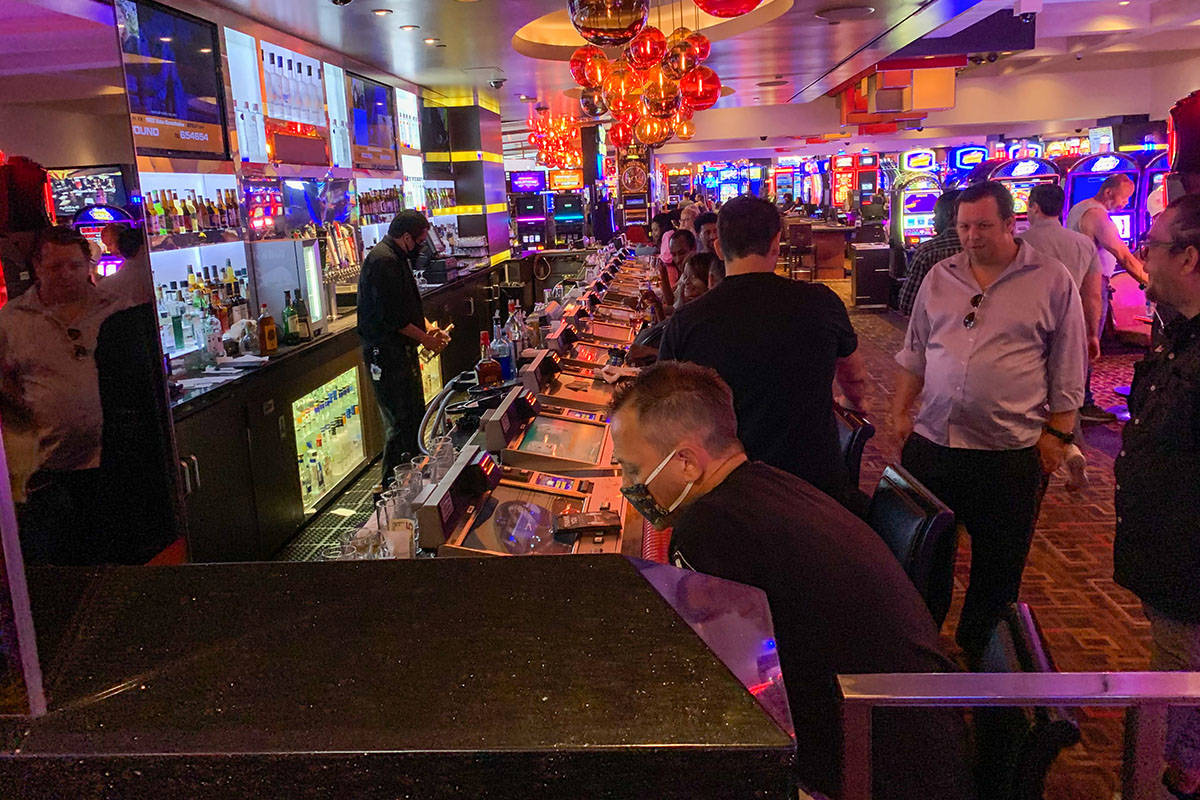 People gamble and order drinks at a bar in the Fremont Hotel and Casino after casinos reopened ...