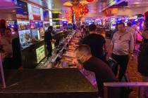People gamble and order drinks at a bar in the Fremont Hotel and Casino after casinos reopened ...