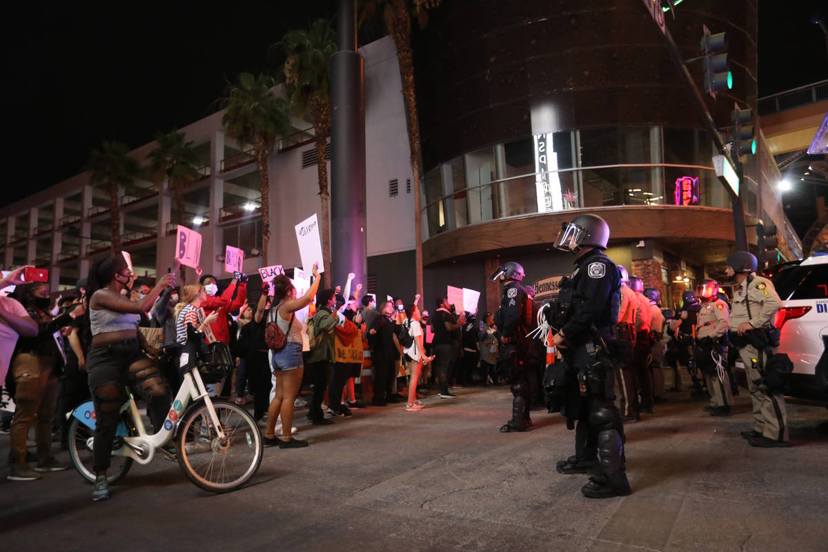 Protesters raise their fists at Las Vegas and North Las Vegas police officers during a Black Li ...