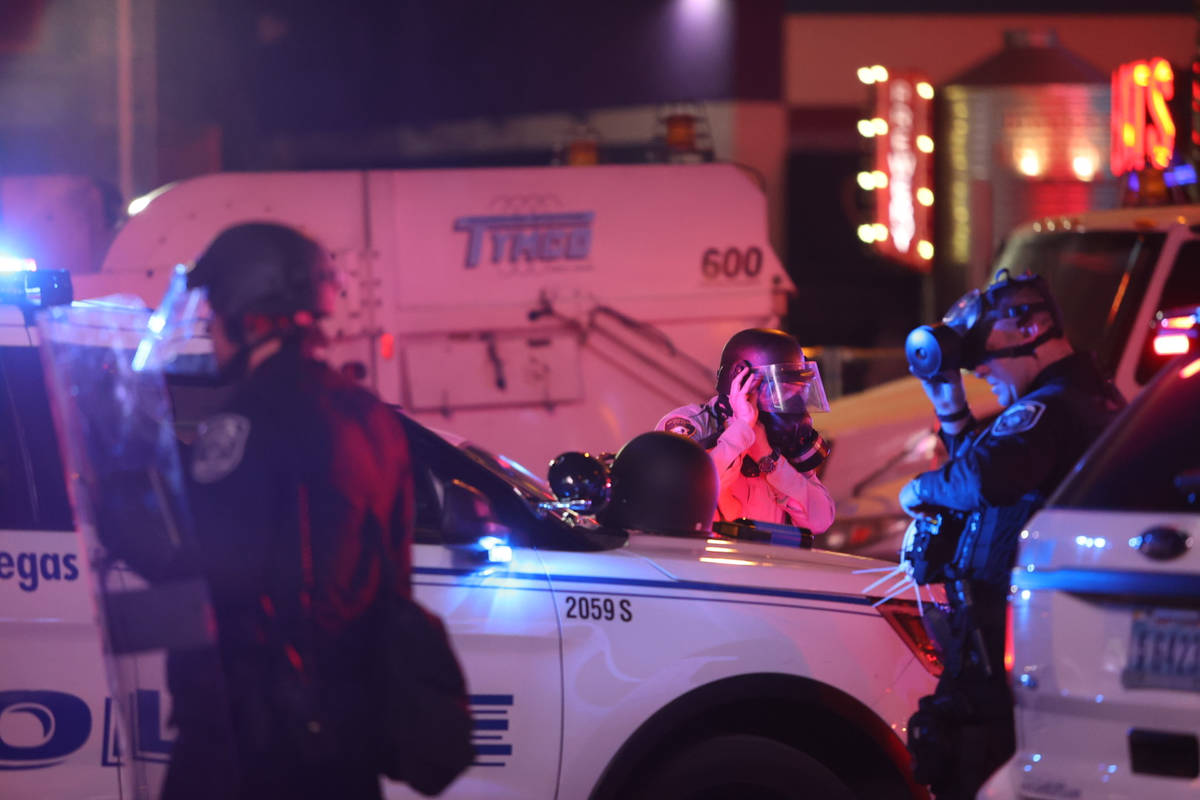 Officers put on gas masks on at Fremont Street and Las Vegas Boulevard South prior to deploying ...