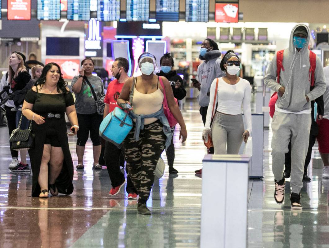 Arriving passengers head toward a baggage claim area at McCarran International Airport on Thurs ...