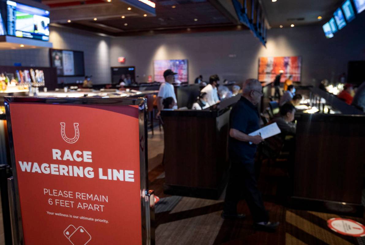 The Race and Sports Book at Palace Station asks customers to remain six feet apart to slow the ...