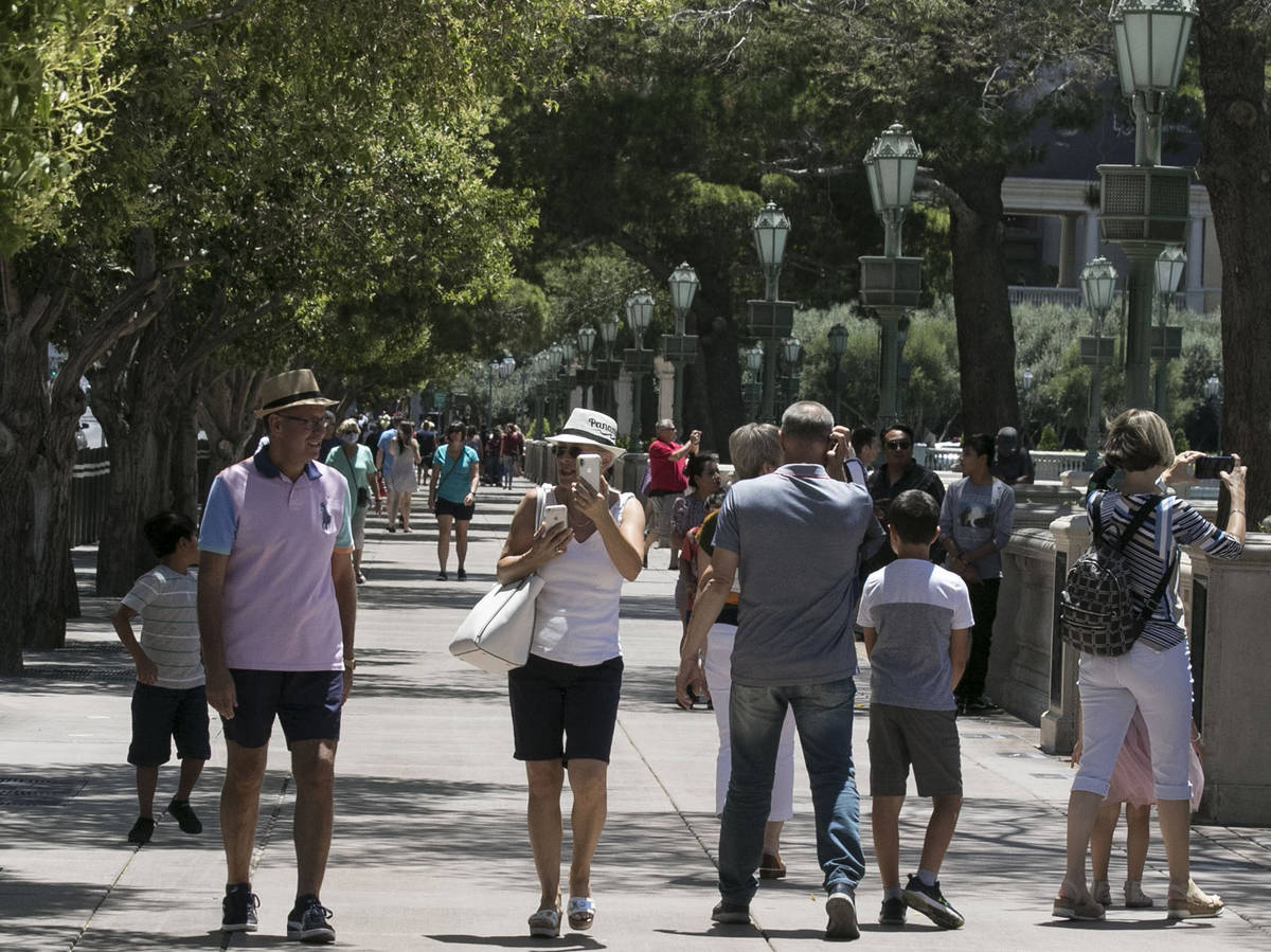 Tourists walk along Las Vegas Boulevard near the Bellagio fountain on Sunday, June 7, 2020, in ...