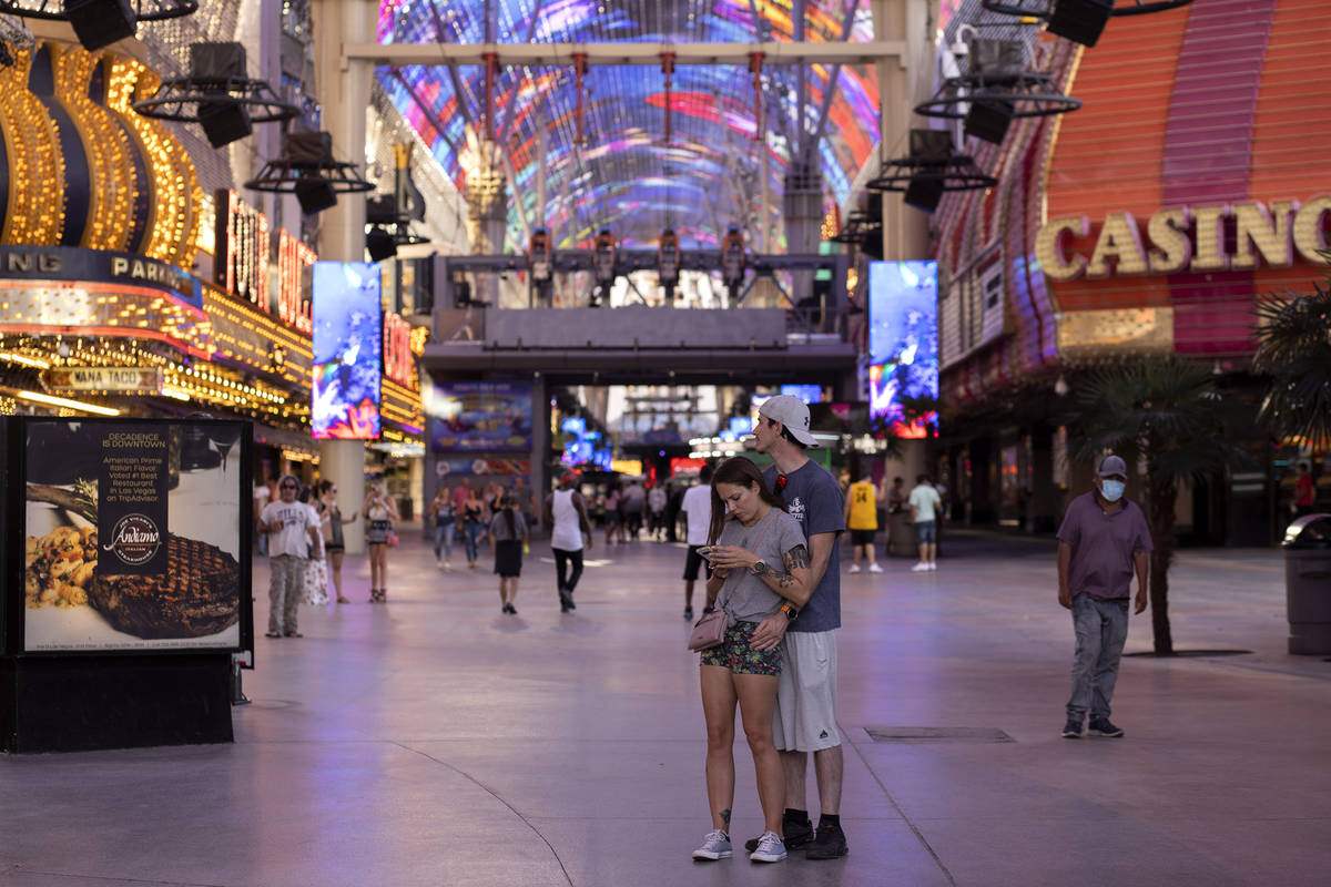 Las Vegas locals Rachel DeGennaro and Kyle Voodre pause in the middle of Fremont Street Experie ...