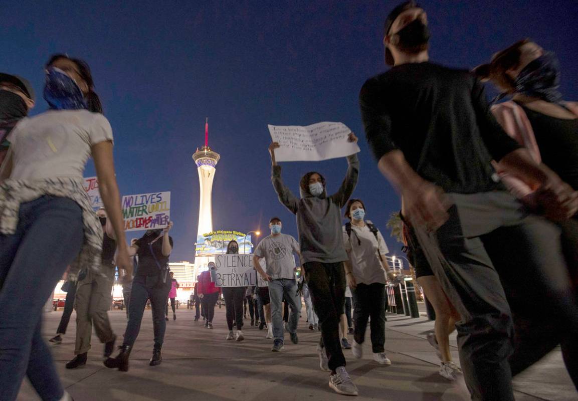 A small group of people march down Las Vegas Boulevard in protest of police brutality and the d ...