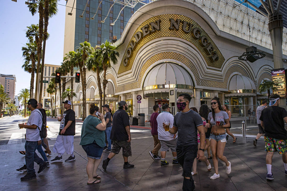 People walk outside of the Golden Nugget at the Fremont Street Experience in downtown Las Vegas ...