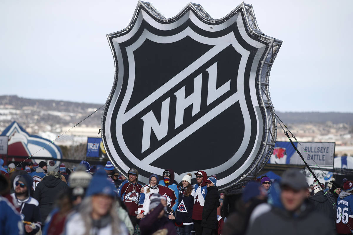 FILE - In this Saturday, Feb. 15, 2020, file photo, fans pose below the NHL league logo at a di ...