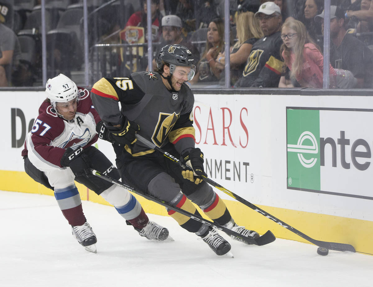 Golden Knights defenseman Jake Bischoff (45) fights for possession with Colorado Avalanche left ...