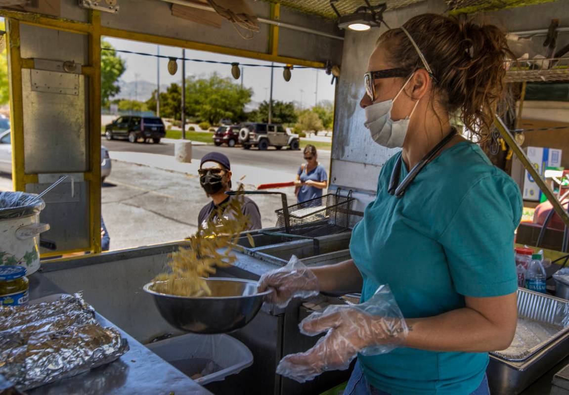 Jenny Noel of the Hot Diggity Dog Las Vegas food truck tosses a bowl of fries with seasonings w ...