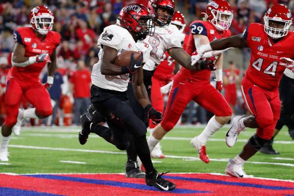 UNLV running back Charles Williams tries to get around Fresno State defensive lineman Leevel Ta ...