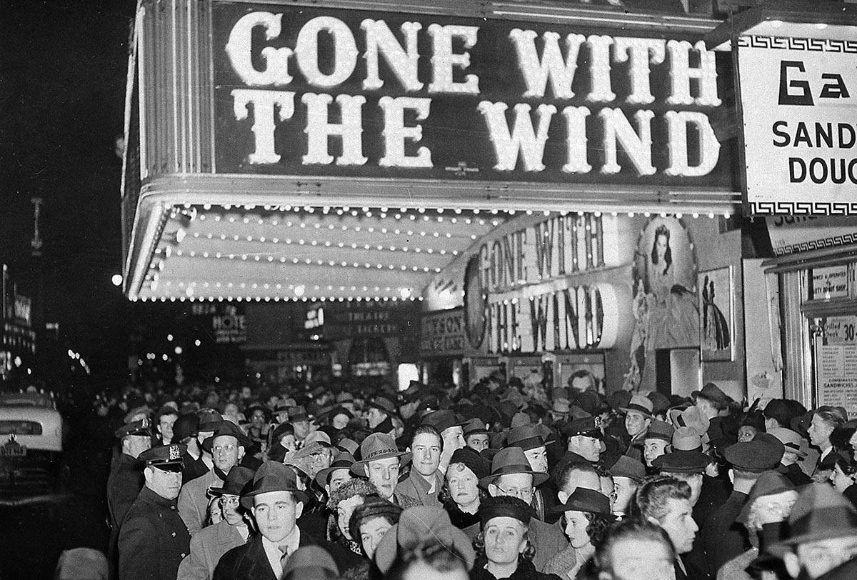 In this Dec. 19, 1939, file photo, a crowd gathers outside the Astor Theater on Broadway during ...