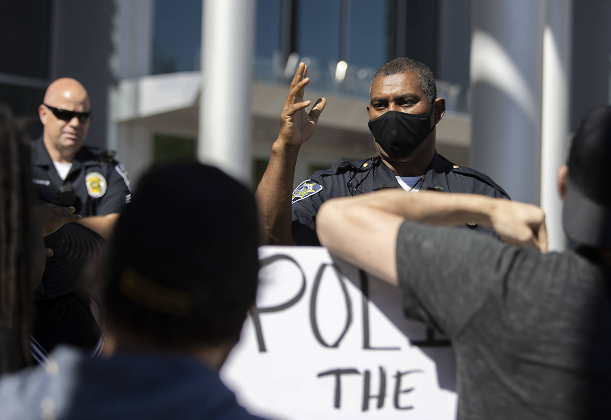 A Las Vegas police officer asks protesters, who asked to see Mayor Goodman to discuss defunding ...