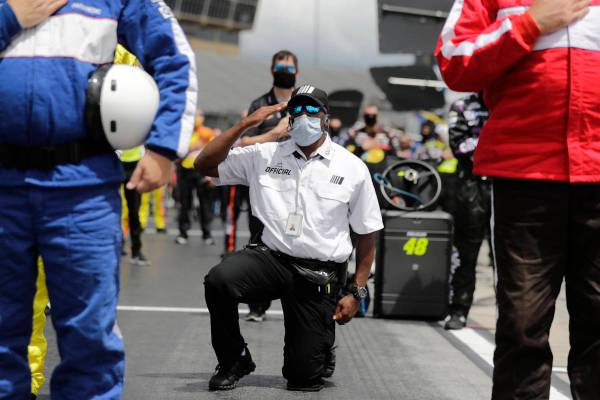 A NASCAR official kneels during the national anthem before a NASCAR Cup Series auto race at Atl ...