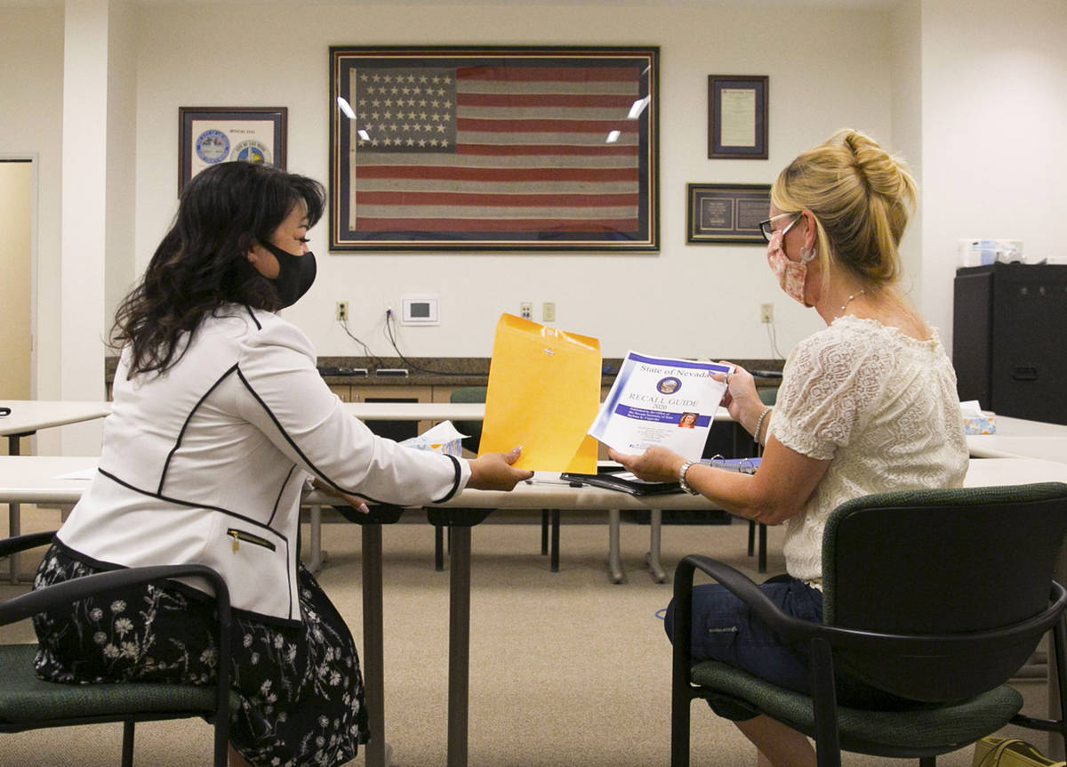 Stacey Campbell, left, chief deputy clerk at the City of Las Vegas, hands out the 2020 recall g ...