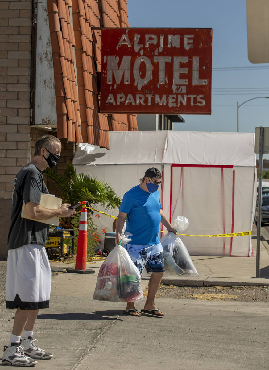 Former resident Matthew Sykes, right, carries away bags of possessions from the Alpine Motel Ap ...