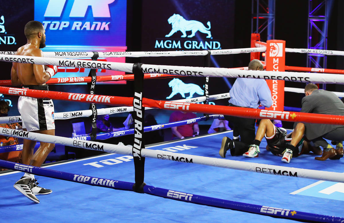 Jessie Magdaleno is attended to after taking a low blow from Yenifel Vicente in the fourth roun ...