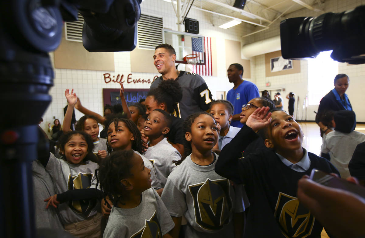 Golden Knights forward Ryan Reaves is surrounded by children during a youth street hockey clini ...
