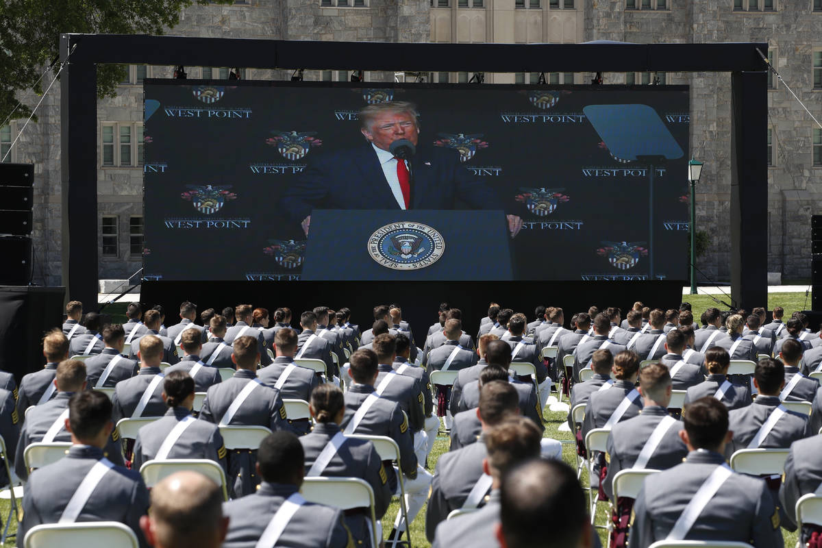 A screen displays President Donald Trump as he speaks to over 1,110 cadets in the Class of 2020 ...