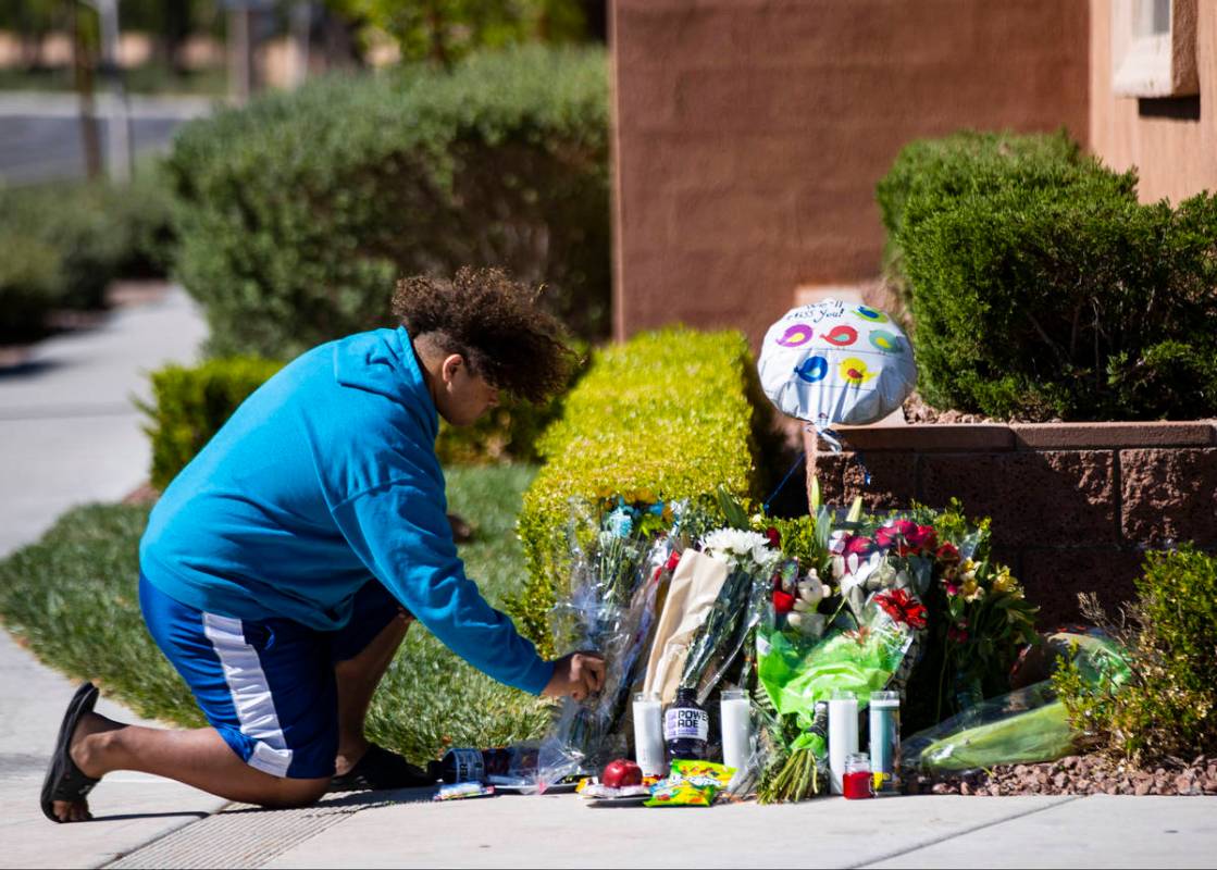 John Taylor, 14, helps arrange items left at the memorial left for David Cox, 18, and Brandon C ...